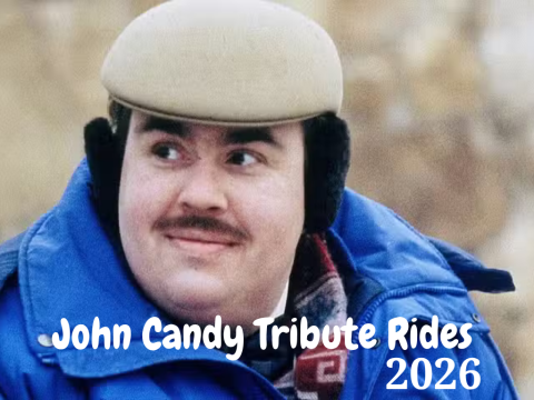 Person in blue coat and hat, text reads 'John Candy Tribute Rides 2026'.