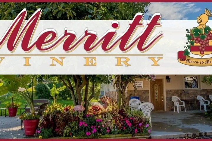 Entrance of Merritt Winery with plants and chairs under a covered area.